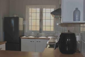 a kitchen with a black refrigerator and white cabinets at Dolphins 25 Stay in Gqeberha