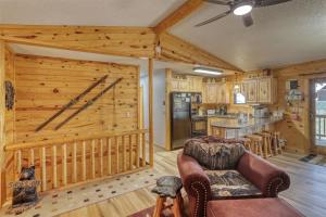 a kitchen and living room with a log wall at Pineview Cabin - Hot Tub in Lead