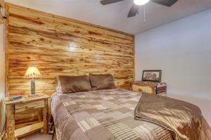 a bedroom with a bed and a wooden wall at Pineview Cabin - Hot Tub in Lead