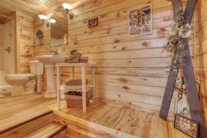 a log cabin bathroom with a sink and a toilet at Pineview Cabin - Hot Tub in Lead +24 photos