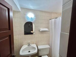 a bathroom with a white toilet and a sink at Hotel Los Angeles in Arequipa +25 photos