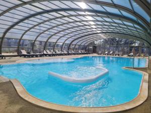 una gran piscina con techo de cristal en Le Chalet d'Angel en Jullouville-les-Pins