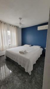 a bedroom with a large white bed with a blue wall at Dunas 3 quartos in Cabo Frio