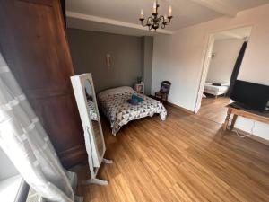 a bedroom with a bed and a wooden floor at Welkom huis in Eecke