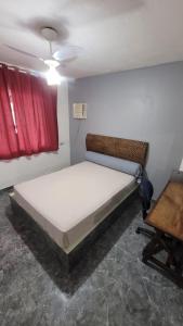 a small bedroom with a bed and a chair at Dunas 3 quartos in Cabo Frio