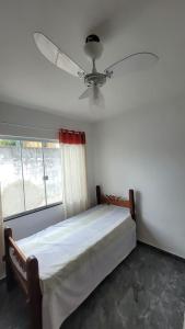 a bedroom with a bed and a ceiling fan at Dunas 3 quartos in Cabo Frio