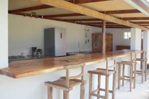 een keuken met een lang houten aanrecht met krukken bij Bungalow Miri in Tevaitoa