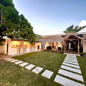 a backyard with a lawn and a house at Bungalow Miri in Tevaitoa