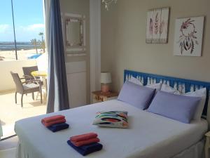 een slaapkamer met een bed met twee handdoeken erop bij Casa Maria Cotillo Mar in Cotillo