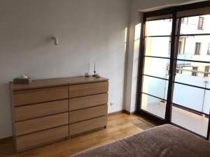 a bedroom with a dresser and a large window at Apartament nad Czarną Hańczą in Suwałki