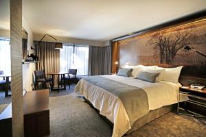 um quarto de hotel com uma cama grande e uma mesa em Hotel Cumbres Lastarria em Santiago