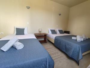 two beds in a room with blue and white at MontNoir Appartement in Mavrovouni