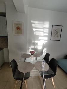 ein Wohnzimmer mit 2 Tischen und 2 Stühlen in der Unterkunft MontNoir Appartement in Mavrovouni