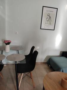 ein Wohnzimmer mit einem Tisch, Stühlen und einem Sofa in der Unterkunft MontNoir Appartement in Mavrovouni