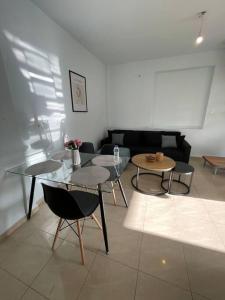 a living room with tables and chairs and a couch at MontNoir Appartement in Mavrovoúnion