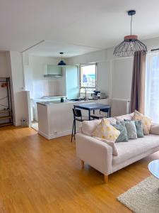 uma sala de estar com um sofá e uma cozinha em Appartement lumineux rénové (proche JO) em Épinay-sur-Seine