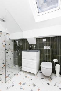 a bathroom with a toilet and a shower at PEAK Aparthotel - Old Town - by CityHost in Braşov +90 photos