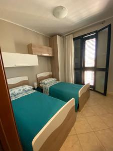 um quarto de hotel com duas camas e uma janela em Aurora em Santa Cesarea Terme