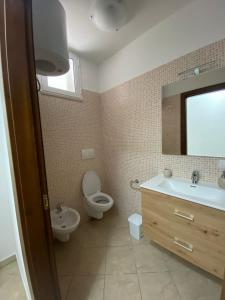 uma casa de banho com um lavatório, WC e um espelho. em Aurora em Santa Cesarea Terme