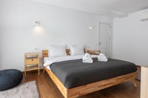 a bedroom with a bed with two shoes on it at PEAK Aparthotel - Old Town - by CityHost in Braşov