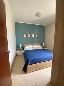 um quarto com uma cama com uma parede azul em Aurora em Santa Cesarea Terme