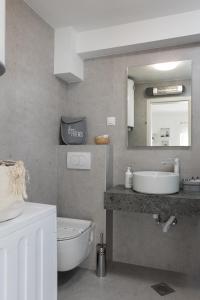 a bathroom with a sink and a mirror and a toilet at Dubrovnik Domus Apartment in Dubrovnik