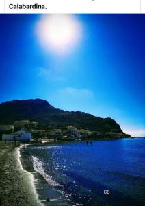 a beach with blue water and a mountain in the background at Casa Del Mar in Águilas