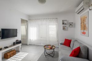 a white living room with a couch and a table at Dubrovnik Domus Apartment in Dubrovnik +24 photos