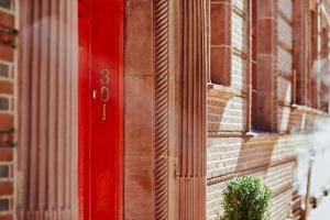 フィラデルフィアにあるアレクサンダー インのレンガ造りの建物の横の赤い扉