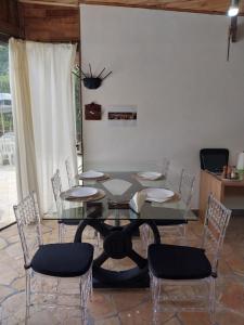 PiraquaraにあるChacara Recanto Vale do Luarのダイニングルーム(ガラスのテーブル、椅子付)