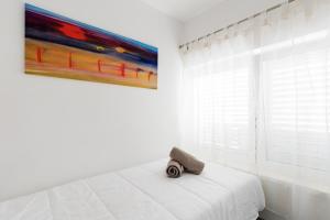 a white bedroom with a painting on the wall at Dubrovnik Domus Apartment in Dubrovnik