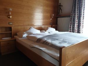 een slaapkamer met een bed met een houten muur bij Garni Le Chalet in Santa Cristina in Val Gardena
