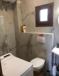 アフィトスにあるAfyAppartの白いトイレと窓のあるバスルーム