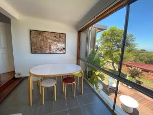 a table and two chairs in a room with a balcony at 4 Bedroom Mid-Century Home with Ocean Views in Bundeena