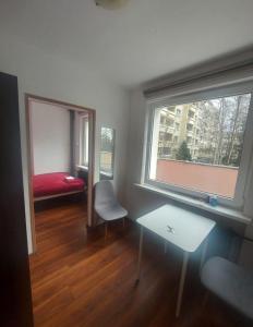 a room with a bed and a table and a window at Travel House Wroclaw in Wrocław