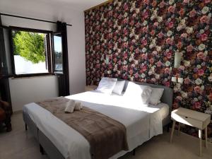 a bedroom with a bed with a floral wall at VILLAMOR in Albufeira +13 photos