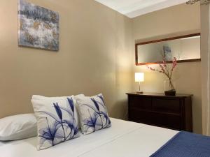 a bedroom with a bed with two pillows and a mirror at Posada Florencia AC near Guanacaste Airport in Liberia