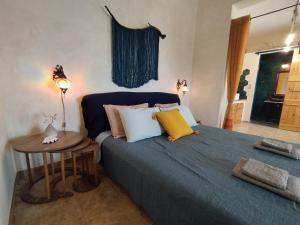 ein Schlafzimmer mit einem blauen Bett mit Kissen und einem Tisch in der Unterkunft PAPs Farm - Alexandria Double Apartment in Gavrio