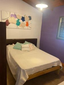 Bett in einem Zimmer mit Wandgemälde in der Unterkunft Cabañas Noe in San Roque