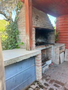 un horno de ladrillo al aire libre en una pared de ladrillo en Cabañas Noe en San Roque