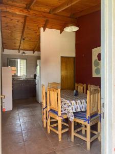 comedor con mesa y sillas y cocina en Cabañas Noe en San Roque