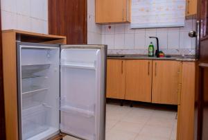 cocina con nevera abierta en Cosystay Apartment, en Abuja