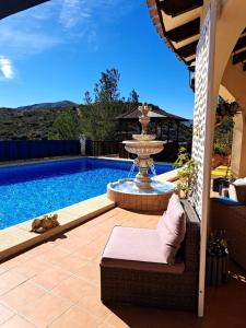 a swimming pool with a fountain in a yard at Sweet Home in Pego