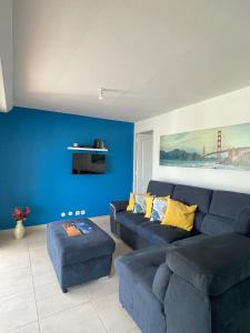 sala de estar con paredes azules y sofá azul en Résidence Subtropicale en Saint-François