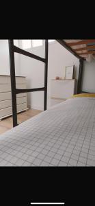 Un dormitorio con una cama blanca de azulejos en una habitación en Precioso piso en Ribeira, en Ribeira