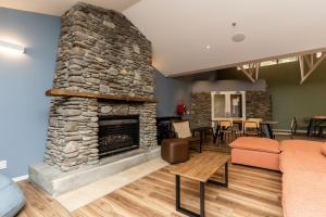 a living room with a stone fireplace at Haka House Franz Josef in Franz Josef