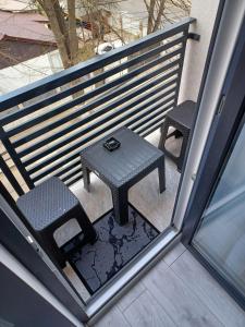 mały stół i 2 krzesła na balkonie w obiekcie ApartHotel Oltului w mieście Gałacz