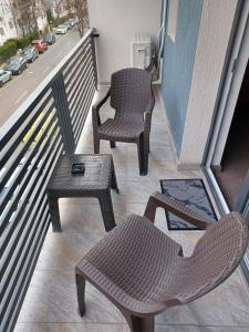 2 sillas y una mesa en el balcón en ApartHotel Oltului, en Galaţi