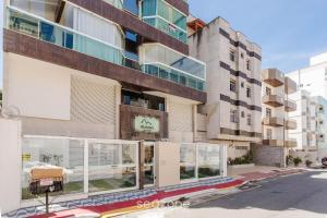 MuquiçabaにあるLindo apto a apenas 400m da Praia do Morro CVE402の通りに面したガラス窓のある高層ビル