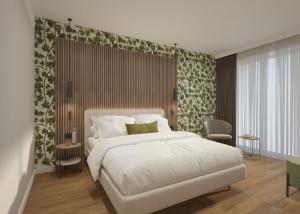 Un dormitorio con una gran cama blanca con papel pintado verde y blanco en Hotel Europa, en Sirmione